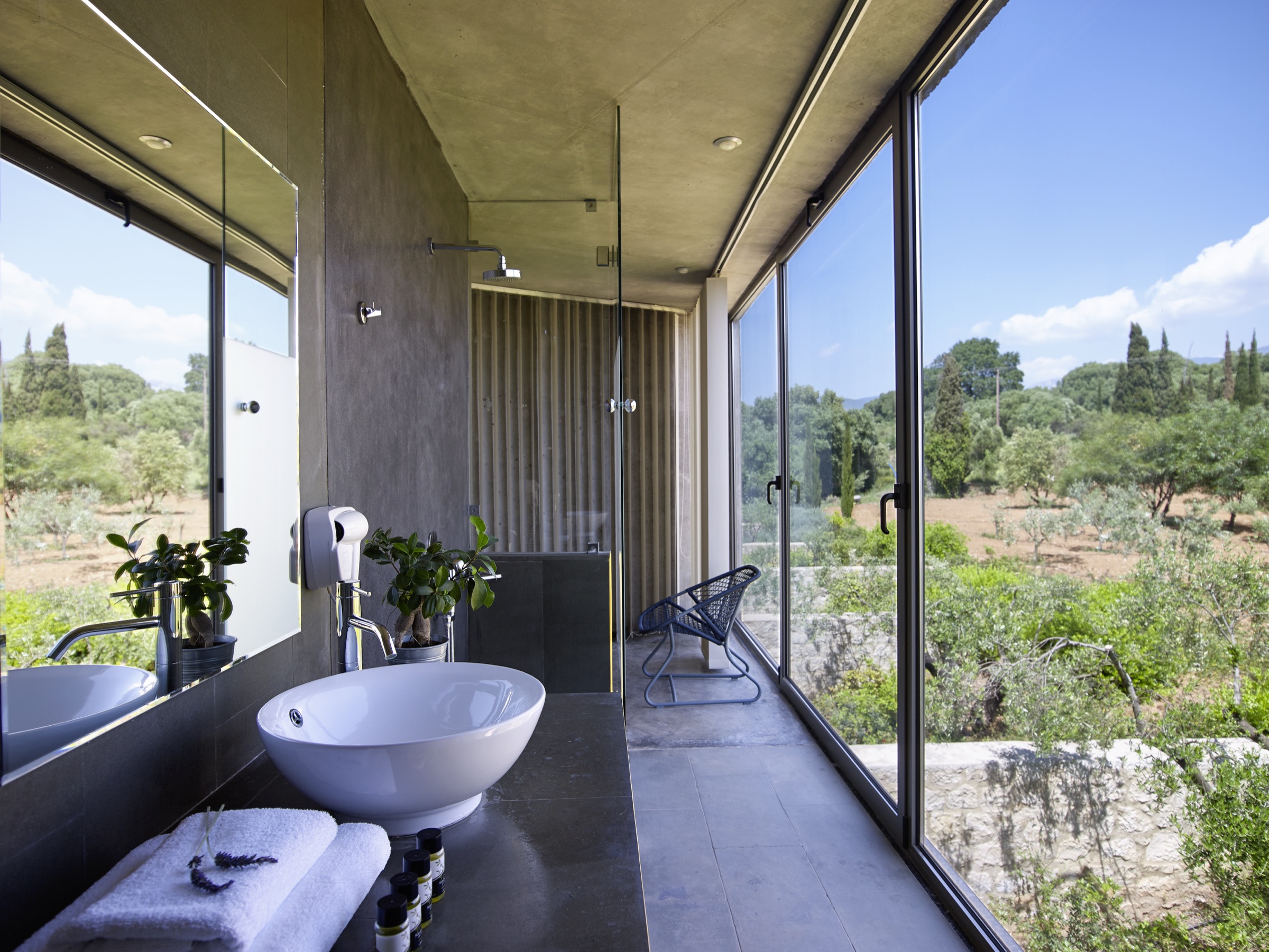 Bathroom with sliding glass walls overlooking the olive grove